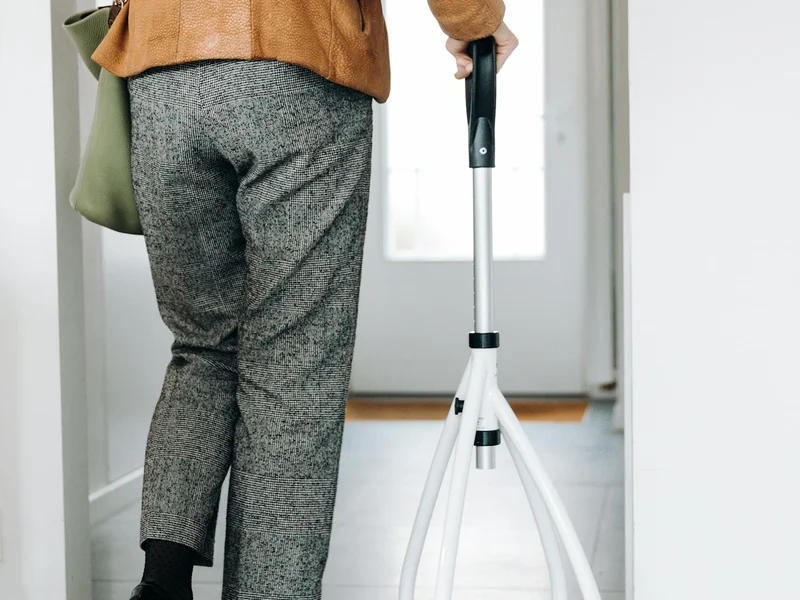 Personne âgée avec déambulateur dans le couloir de son domicile
