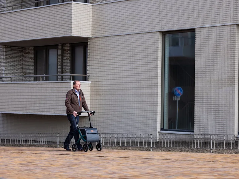 Homme âgé se promenant avec un rollator sur le trottoir