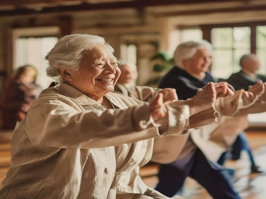 Groupe de seniors pratiquant le tai-chi dans une salle communale lumineuse