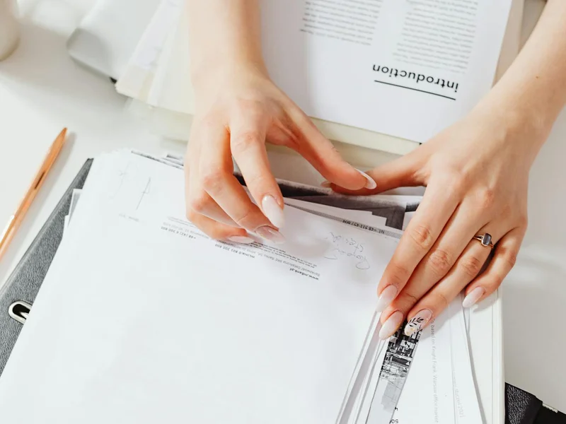 Mains gérant des documents administratifs — démarches de retour à domicile